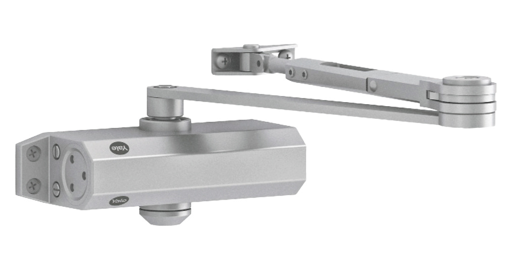 YALE-DOORCLOSER-3500-RET Vista frontal del cierrapuertas Yale YALE-DOORCLOSER-3500-RET, con brazo articulado y acabado plata, ideal para puertas pesadas con alta frecuencia de uso y necesidades de cierre automático fiable